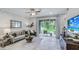 Bright and open living room with modern decor, neutral color palette, large window, and tile flooring at 11347 Crescent Deer Dr, Land O Lakes, FL 34638