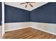Bedroom featuring blue walls, white trim, wood flooring and a ceiling fan at 1166 Lumsden Trace Cir, Valrico, FL 33594
