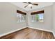 Inviting bedroom features hardwood floors, a ceiling fan, and two windows with natural light inside the home at 1166 Lumsden Trace Cir, Valrico, FL 33594