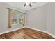 Bedroom featuring neutral walls, wood flooring, a window and a ceiling fan at 1166 Lumsden Trace Cir, Valrico, FL 33594