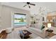 Bright living room featuring a ceiling fan, hardwood floors, and sliding glass doors to a beautiful outdoor pool area at 1166 Lumsden Trace Cir, Valrico, FL 33594
