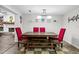 Inviting dining room features rustic wood table, bench, red chairs, stylish lighting, and decorative shelving at 11950 117Th St, Seminole, FL 33778