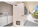 Laundry facility featuring a washer and dryer, with a well-lit outdoor hallway nearby at 139 Bluff View Dr # 105, Belleair Bluffs, FL 33770
