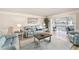 Comfortable living room featuring a soft blue sofa and a view into a sunroom at 139 Bluff View Dr # 105, Belleair Bluffs, FL 33770