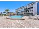 Relaxing community pool with lounge chairs for sunbathing and a covered area for shaded seating at 139 Bluff View Dr # 105, Belleair Bluffs, FL 33770