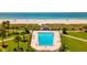 Aerial view of a beachside swimming pool surrounded by lush landscaping and tiki huts at 1400 Gulf Blvd # 204, Clearwater Beach, FL 33767