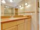 Bathroom featuring a large mirror, light wood cabinets, and sconce lighting at 1400 Gulf Blvd # 204, Clearwater Beach, FL 33767