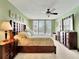 Bedroom featuring a king bed, dark wood furniture, a ceiling fan, and balcony access at 1400 Gulf Blvd # 204, Clearwater Beach, FL 33767