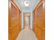 Hallway with closet and neutral tile leading to a light-filled bathroom with white towels at 1400 Gulf Blvd # 204, Clearwater Beach, FL 33767