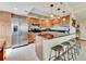 Kitchen featuring stainless steel appliances, wood cabinets, and granite countertops with breakfast bar at 1400 Gulf Blvd # 204, Clearwater Beach, FL 33767