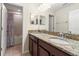 Bathroom featuring double sinks, granite countertops, and a shower with colorful curtain at 18855 Hampstead Heath Ct, Land O Lakes, FL 34638