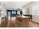 Open-concept dining area featuring wood floors, modern chandelier, and seamless flow into the living room at 18855 Hampstead Heath Ct, Land O Lakes, FL 34638