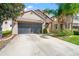 Charming home featuring a large garage, lush landscaping, and a welcoming front entrance at 18855 Hampstead Heath Ct, Land O Lakes, FL 34638