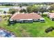 Aerial view of a home with a beautiful pond and landscaping, enclosed lanai, and a serene surrounding area at 2020 Nantucket Dr # 32, Sun City Center, FL 33573