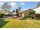 Manicured backyard featuring lush green lawn, mature trees and patio with furniture at 308 S Arrawana Ave, Tampa, FL 33609