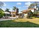 Large backyard with lawn, mature trees, and outdoor patio seating area at 308 S Arrawana Ave, Tampa, FL 33609