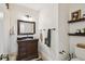 Bathroom featuring a dark vanity with granite countertop, decorative shelves, and neutral wall color at 308 S Arrawana Ave, Tampa, FL 33609