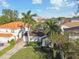 Charming home with a well-manicured lawn, lush landscaping, and mature palm trees, offering delightful curb appeal at 308 S Arrawana Ave, Tampa, FL 33609