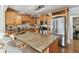 Beautiful kitchen features an island with seating, granite counters, stainless steel appliances, and wood cabinetry at 308 S Arrawana Ave, Tampa, FL 33609