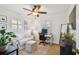 Bright home office featuring a ceiling fan, white desk, neutral rug, and comfortable seating area at 308 S Arrawana Ave, Tampa, FL 33609