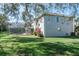 View of the home's exterior from the lush green lawn, pool and lanai at 4037 Auston Way, Palm Harbor, FL 34685