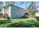 View of the home's exterior from the lush green lawn and garden at 4037 Auston Way, Palm Harbor, FL 34685