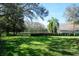 Well-maintained backyard with lush green grass and palm trees at 4037 Auston Way, Palm Harbor, FL 34685