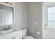 This powder room features a vanity with a sink, toilet, and white door with a window at 4037 Auston Way, Palm Harbor, FL 34685