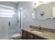 Bathroom with a granite-topped vanity and a glass-enclosed walk-in shower at 4037 Auston Way, Palm Harbor, FL 34685