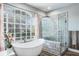 A well-lit bathroom with a soaking tub, a large shower, and a large window at 4037 Auston Way, Palm Harbor, FL 34685