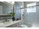 Modern bathroom featuring a glass enclosed shower, mosaic wall accents, and white cabinets at 4037 Auston Way, Palm Harbor, FL 34685