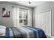 Bedroom featuring a bed with a blue comforter, ceiling fan, and a window with decorative curtains at 4037 Auston Way, Palm Harbor, FL 34685