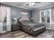 A bright bedroom featuring wood-look flooring, a ceiling fan, and natural light from the window at 4037 Auston Way, Palm Harbor, FL 34685