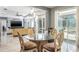 Open dining area with a glass table, ornate chairs, and glass doors opening to the pool at 4037 Auston Way, Palm Harbor, FL 34685