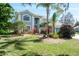 Landscaped front yard featuring lush green lawn and flowering plants enhancing curb appeal at 4037 Auston Way, Palm Harbor, FL 34685