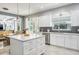 Open kitchen with white cabinets, stainless steel appliances, and an island adjacent to the dining area at 4037 Auston Way, Palm Harbor, FL 34685