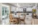 Bright kitchen with a center island, white cabinets, stainless steel appliances, and an adjacent dining area at 4037 Auston Way, Palm Harbor, FL 34685