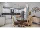 Well-lit kitchen featuring white cabinets, stainless steel appliances, and a stylish dining area at 4037 Auston Way, Palm Harbor, FL 34685
