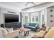 Comfortable living room featuring a blue sofa, modern furniture, and large windows for natural light at 4037 Auston Way, Palm Harbor, FL 34685