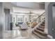 Open-concept living room with large windows, plantation shutters, stylish seating, and staircase at 4037 Auston Way, Palm Harbor, FL 34685