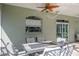 Covered patio with an outdoor seating area, brick flooring, and a ceiling fan at 4037 Auston Way, Palm Harbor, FL 34685