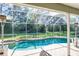 Screened-in pool and patio featuring a brick deck, spa, outdoor seating, and a heat lamp at 4037 Auston Way, Palm Harbor, FL 34685