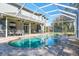 View of the screened pool featuring a brick deck, spa, outdoor seating, and heat lamps at 4037 Auston Way, Palm Harbor, FL 34685