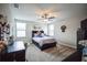 Cozy carpeted bedroom with ceiling fan, filled with a variety of decorations and lots of natural light from the windows at 4716 W Coachford Dr, Wesley Chapel, FL 33543