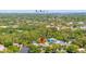An aerial view capturing a home in a densely wooded residential area near the coast and cityscape at 5909 Canton S St, St Petersburg, FL 33712