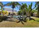 Backyard with lush landscaping, a shed, pool, and covered patio on a sunny day at 5909 Canton S St, St Petersburg, FL 33712