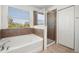 Bright bathroom featuring a soaking tub, separate glass shower, and a large window at 5909 Canton S St, St Petersburg, FL 33712