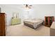 Well-lit bedroom featuring a ceiling fan, a patterned comforter and plenty of storage with dual dressers at 5909 Canton S St, St Petersburg, FL 33712