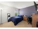 Bedroom featuring a blue bed, wood dresser, purple accent wall, and carpeted floors at 5909 Canton S St, St Petersburg, FL 33712