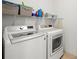 Convenient laundry room equipped with a modern washer and dryer and ample storage shelving at 5909 Canton S St, St Petersburg, FL 33712